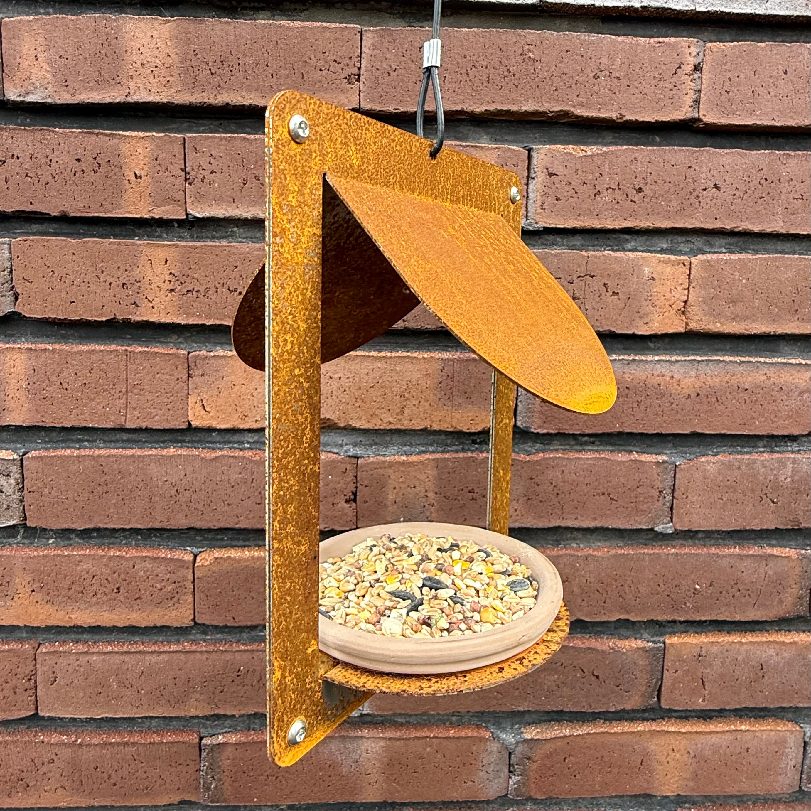 Design vogelvoederhuis WINGS van cortenstaal met terracotta schaaltje
