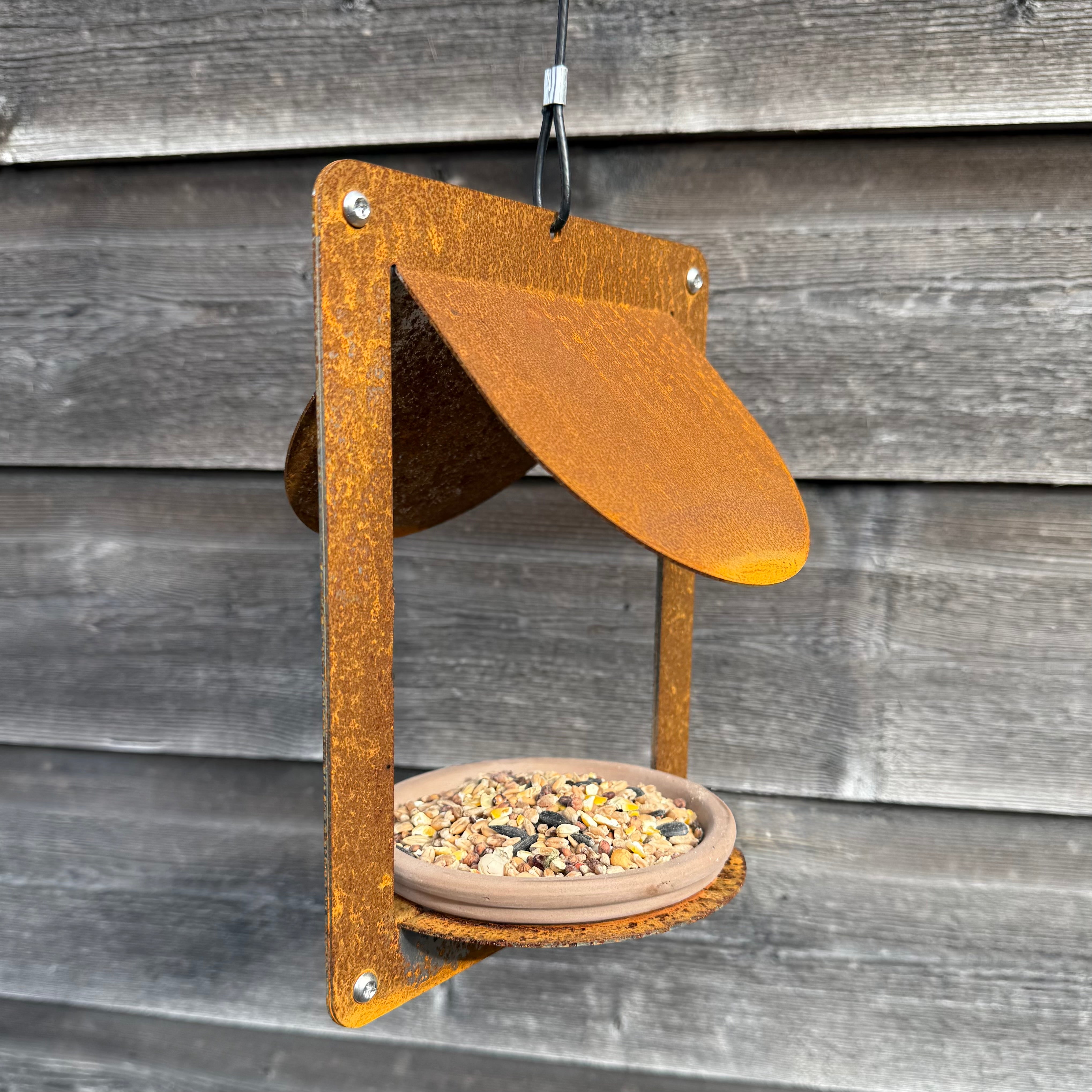 Design vogelvoederhuis WINGS van cortenstaal met terracotta schaaltje